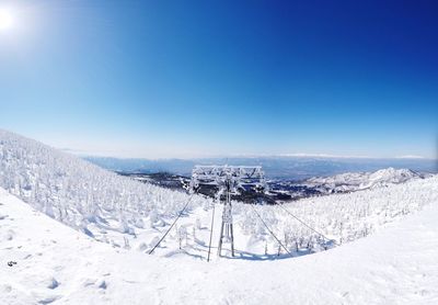 Snow covered land against blue sky