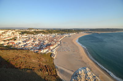 High angle view of sea and buildings against clear sky