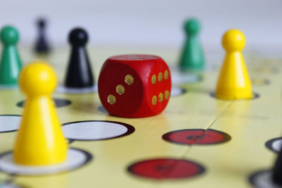 Close-up of game pieces and dice on ludo