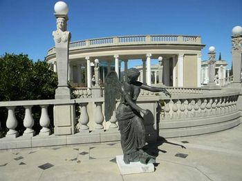 Statues in city against clear sky