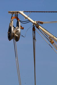 Fishing boat pulley against the blue sky