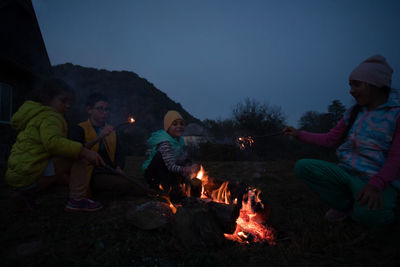 Rear view of man standing by campfire