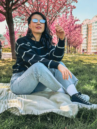 Portrait of young woman sitting on field