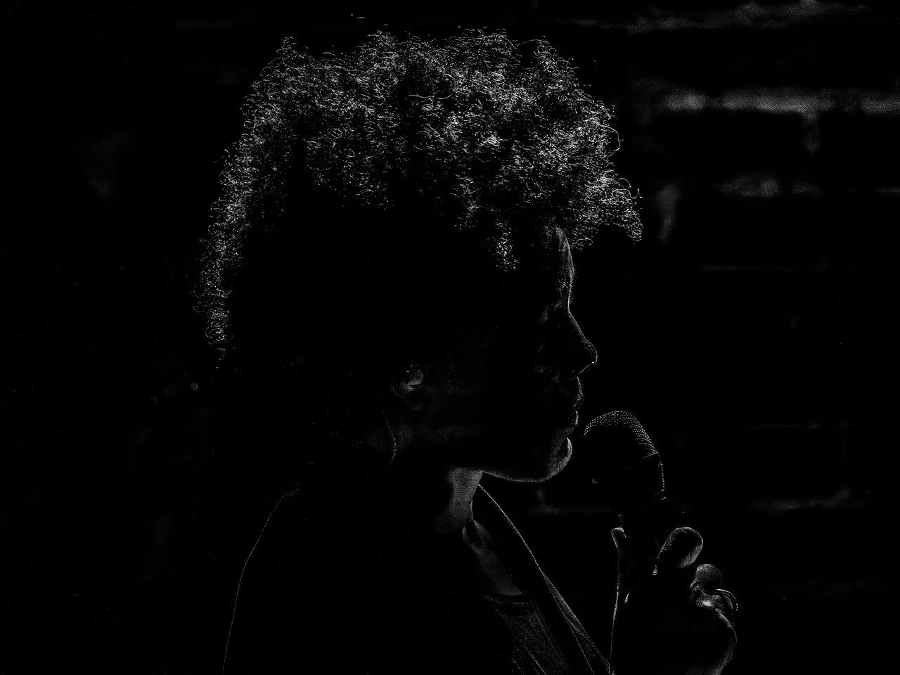 darkness, black, black and white, one person, portrait, headshot, monochrome, monochrome photography, adult, young adult, dark, indoors, lifestyles, light, looking, close-up, leisure activity, curly hair, black background, contemplation, sadness, hairstyle, men