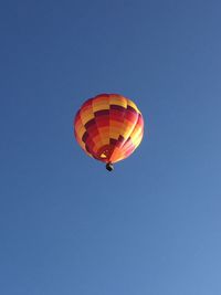 Low angle view of hot air balloon against clear blue sky