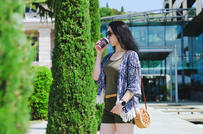 Young happy business woman relaxing in city, outdoor cafe. drinking coffee. using phone. summer