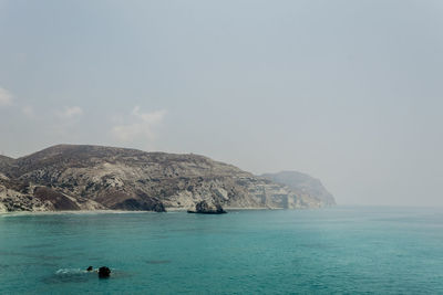 Scenic view of sea and mountains against sky