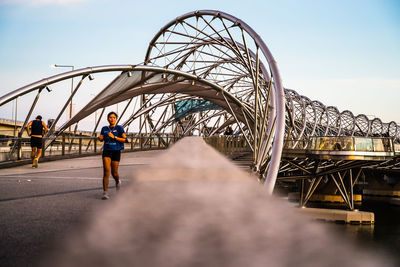 People on bridge against sky