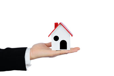 Close-up of hand holding paper against white background