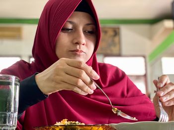 Portrait of teenage girl sitting on table at restaurant