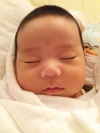 Close-up of baby boy sleeping in bed