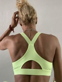 Midsection of shirtless woman standing against wall