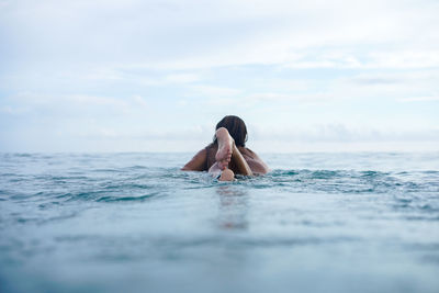 Woman swimming in sea against sky