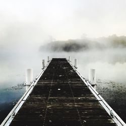 Pier in foggy weather against sky