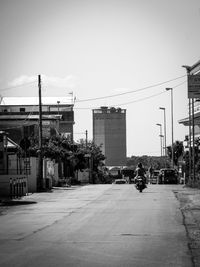 Cars on road against sky in city