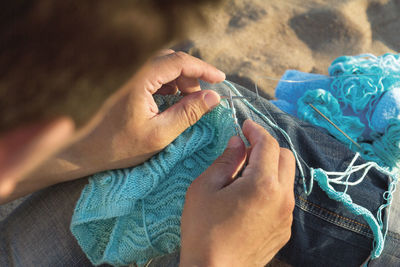 Cropped hands of woman knitting sweater