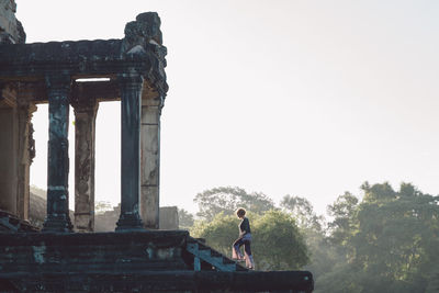 Side view of woman at old ruins in forest