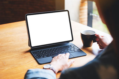 Midsection of woman using laptop on table