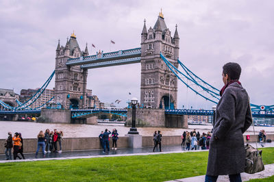 People standing against tower bridge in city