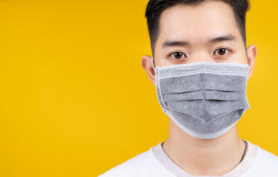 Portrait of young man against yellow background