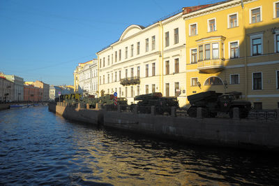 Canal amidst buildings in city against clear sky