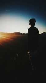 Rear view of silhouette man standing against clear sky