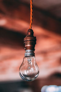 Close-up of light bulb hanging from ceiling