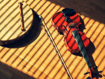 High angle view of violin and frame drum on table