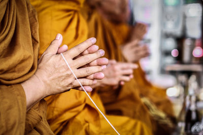 Midsection of monks praying in temple