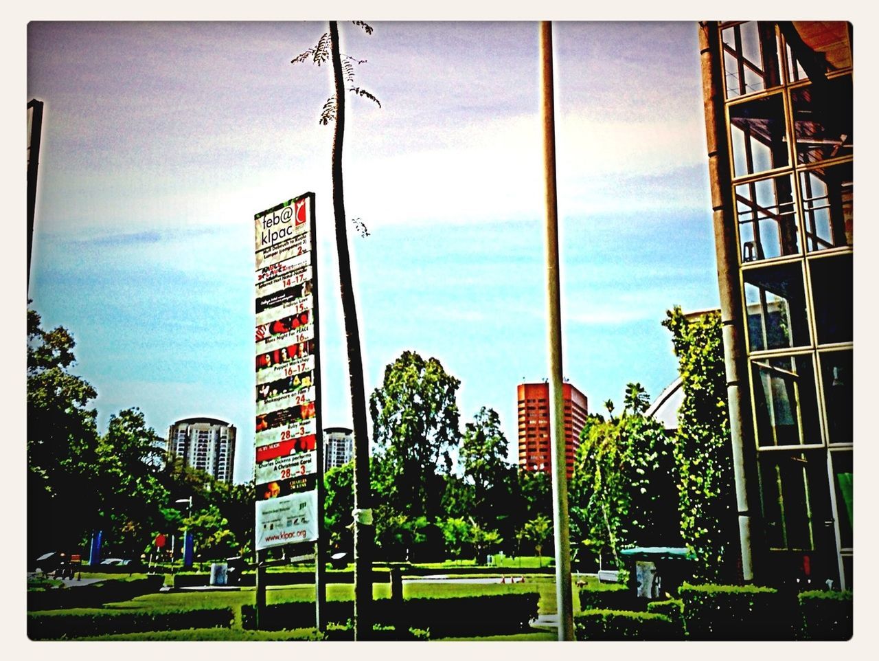 transfer print, building exterior, architecture, built structure, sky, auto post production filter, tree, cloud - sky, city, street light, low angle view, cloud, road sign, day, cloudy, pole, western script, outdoors, text, communication