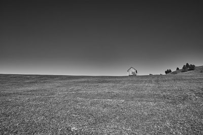 Man riding motorcycle on field against clear sky