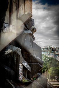 Close-up of statue against buildings