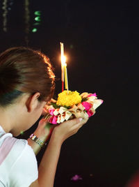 Close-up of woman praying while holding religious offerings