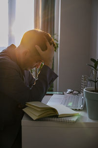 Side view of man working at table