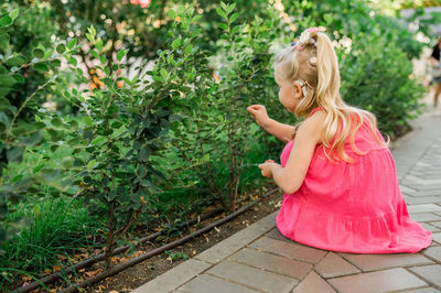 Portrait of young woman standing against plants