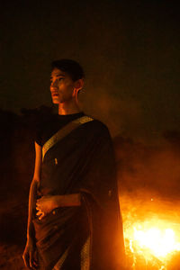 Portrait of young man standing at night