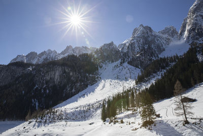 Scenic view of snow covered landscape against bright sun