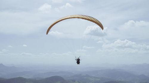 Person paragliding against sky