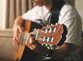 Midsection of woman playing guitar