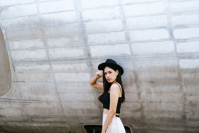 Portrait of woman standing against wall