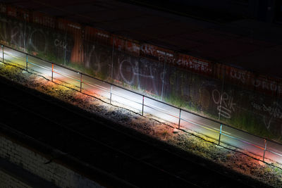 Illuminated railroad tracks at night