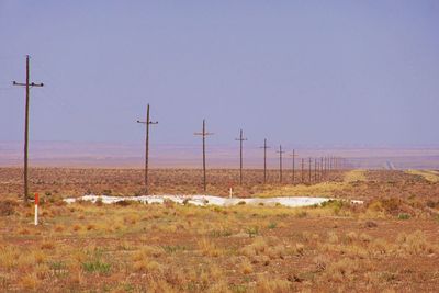 Electricity pylon on field against clear sky