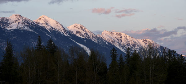 The sun sets on snow covered mountains on a spring day in the coast mountains of british columbia.