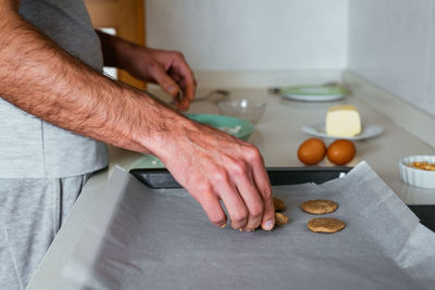 Young man making cookies at the kitchen