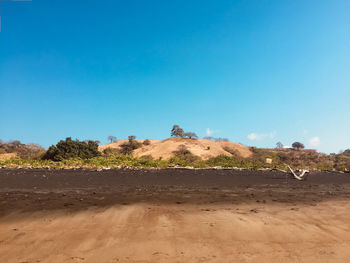 Scenic view of desert against clear blue sky