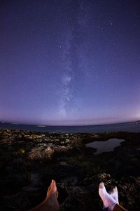 Low section of people at beach against sky at night