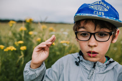 Close-up boy with plant in nose outdoors