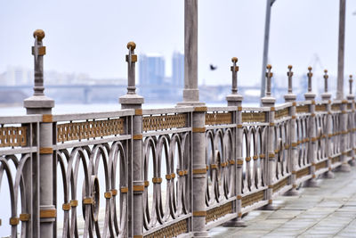 Row of metal railing against sky