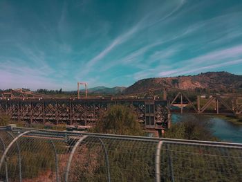 Bridge over mountain against sky