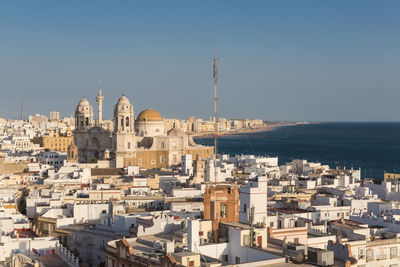 Aerial view of buildings in city against clear sky